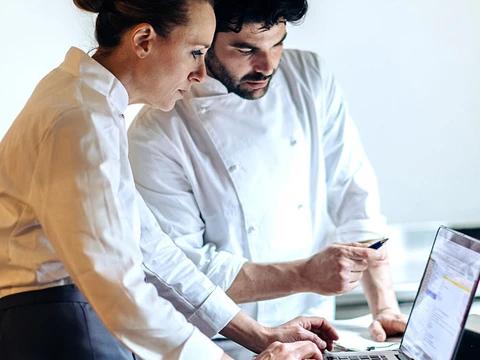 mann und frau schauen auf laptop